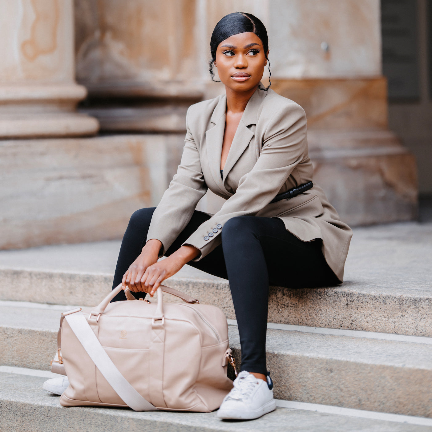 Frau sitzt mit Weekender Linus in sand auf den Treppen