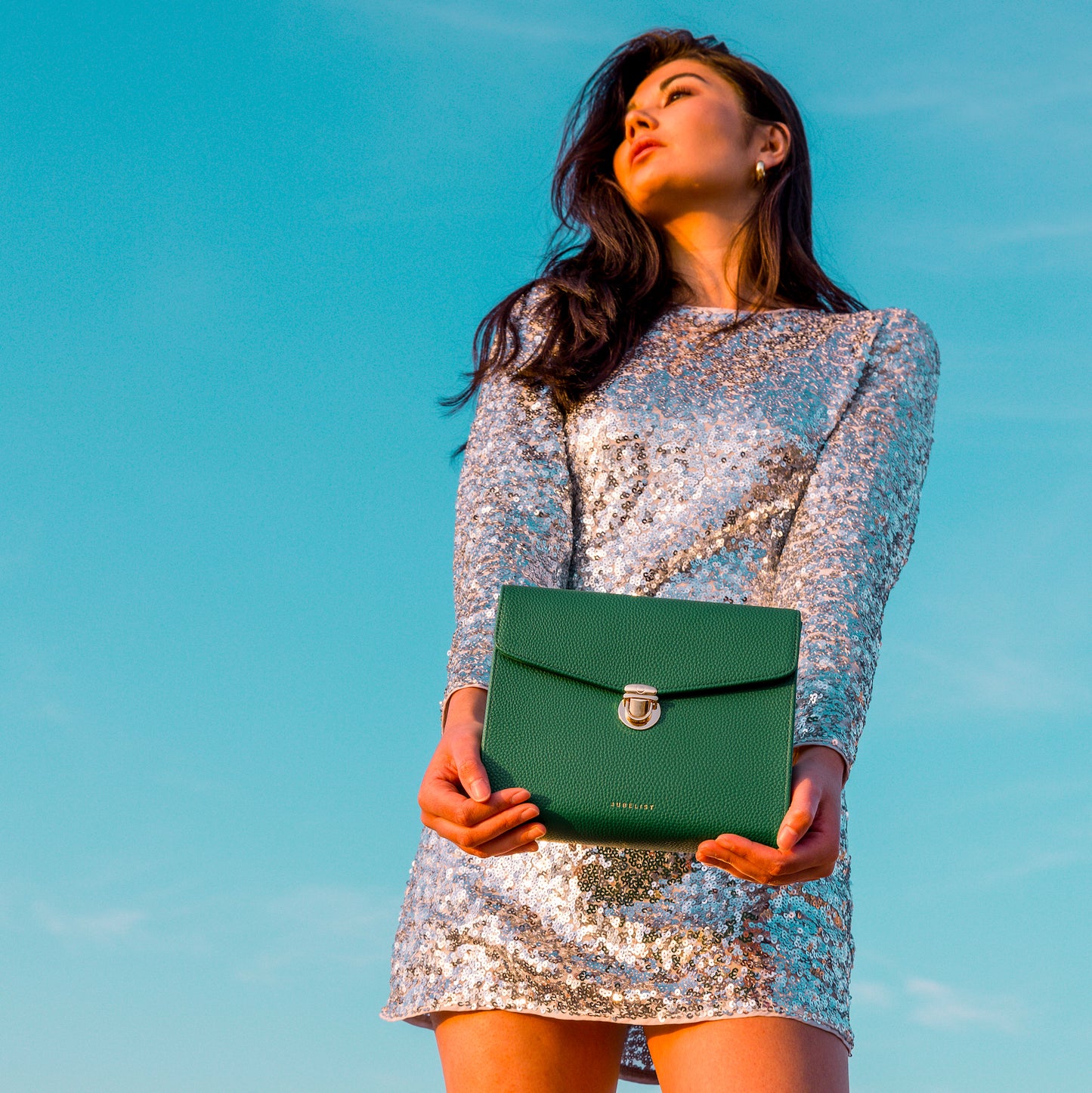 Das Model trägt das Glitzerkleid und hält die gründe Day & Night 2.0 in die Kamera.