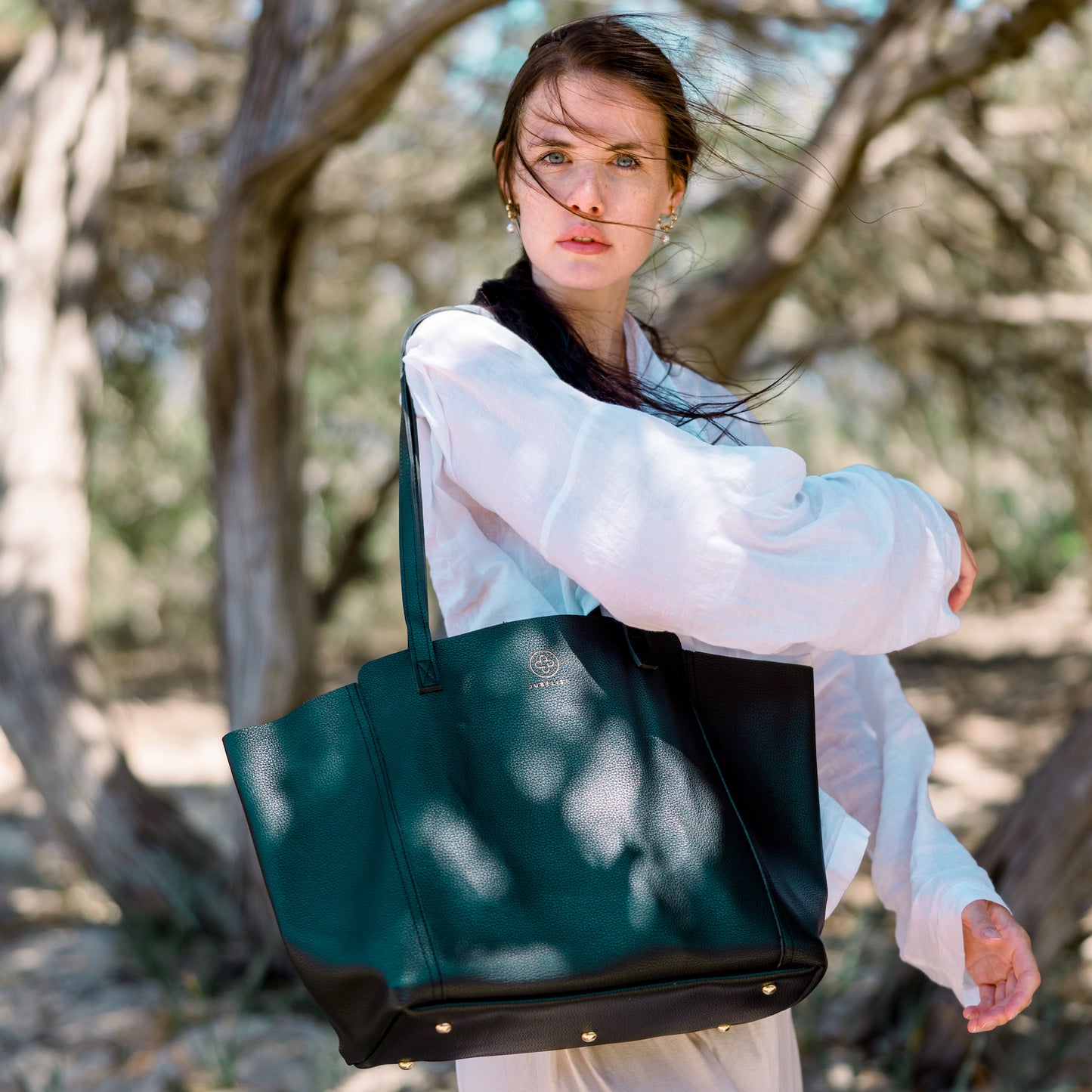 Die Victoria in schwarz wird von einem Model in weißem Leinenhemd getragen.