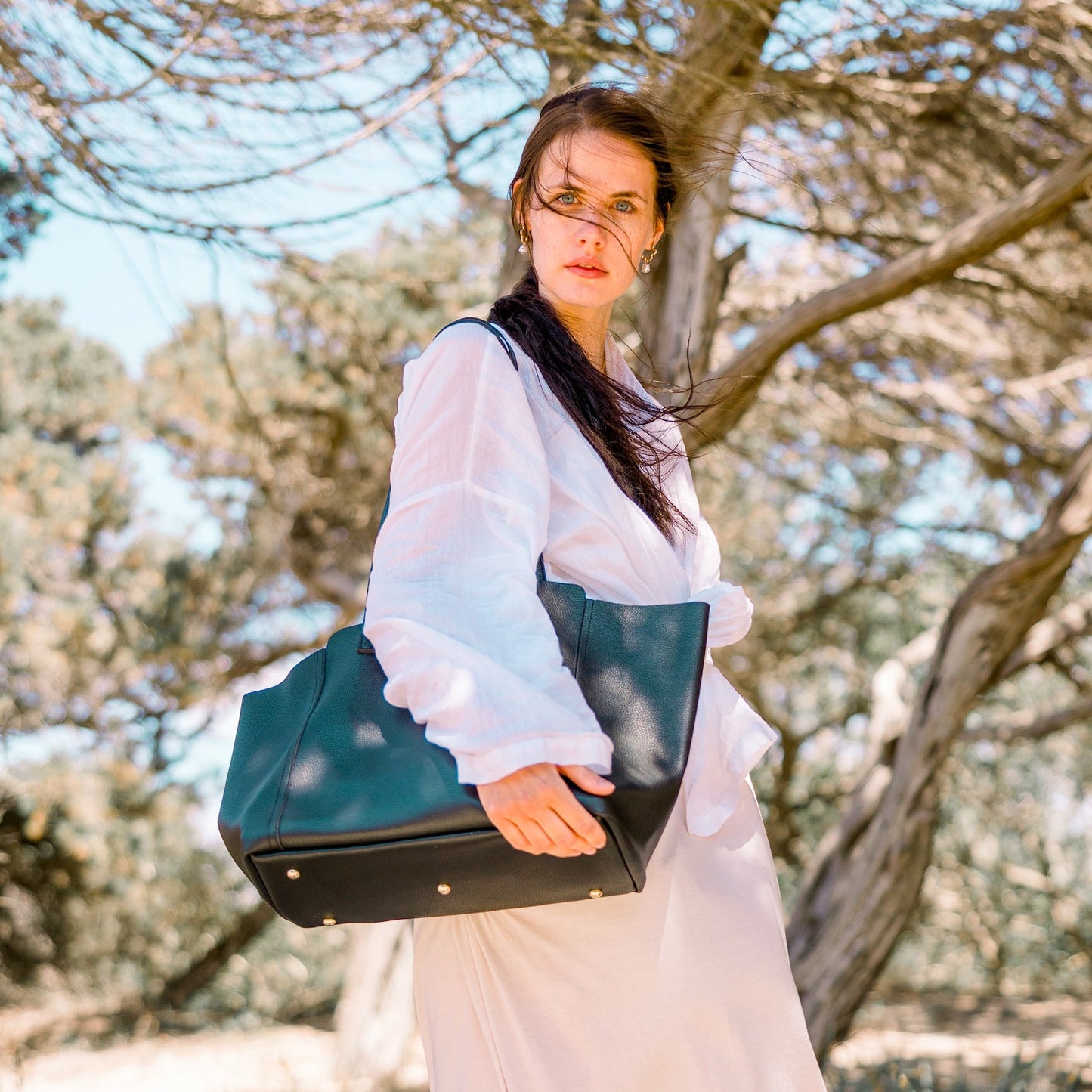 Die Victoria in schwarz wird von einem Model in weißem Leinenhemd getragen.