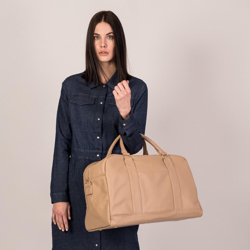 Der Linus in sand wird an den Henkeln in der Armbeuge getragen