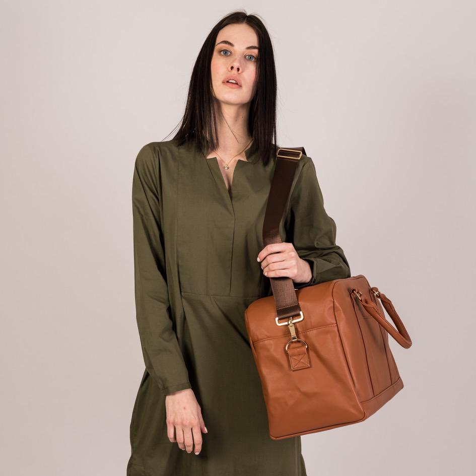 Der Linus in hazelnut wird mit seinem passenden Tragegurt über der Schulter getragen