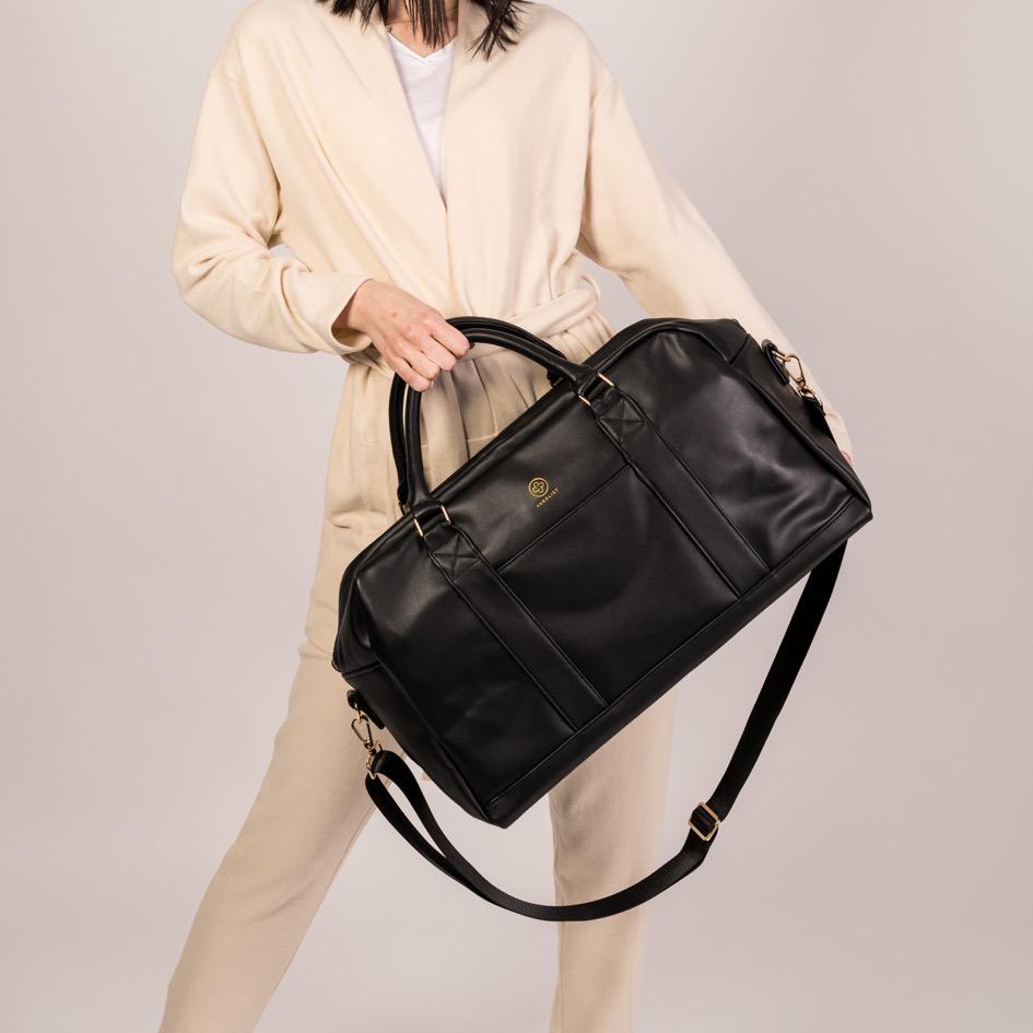 Der Linus in schwarz wird an den Griffen schräg vor dem  Körper getragen und der dazu gehörige Gurt hängt locker herunter