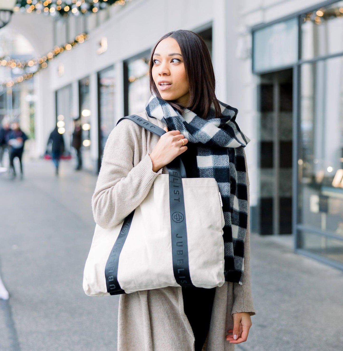 Eine junge Frau trägt den Canvas Shopper mit schwarzen Griffen über der Schulter