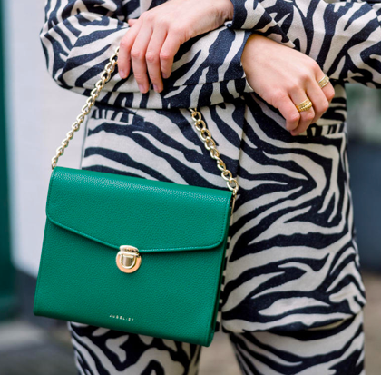 Die Day& Night 2.0 in grün wird als Nahaufnahme gezeigt. Sie hängt mit der Kette über einem Unterarm