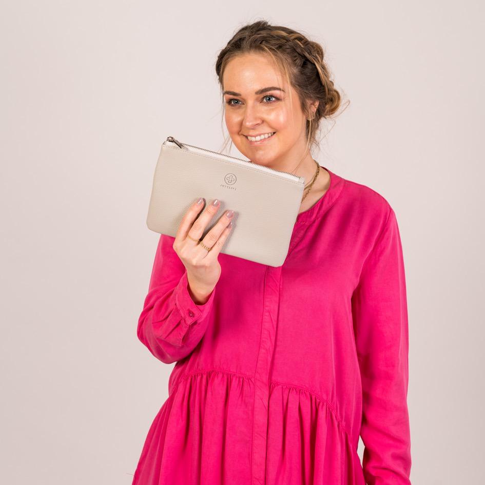 Die Pouch in stone wird mit einer Hand in die Kamera gehalten