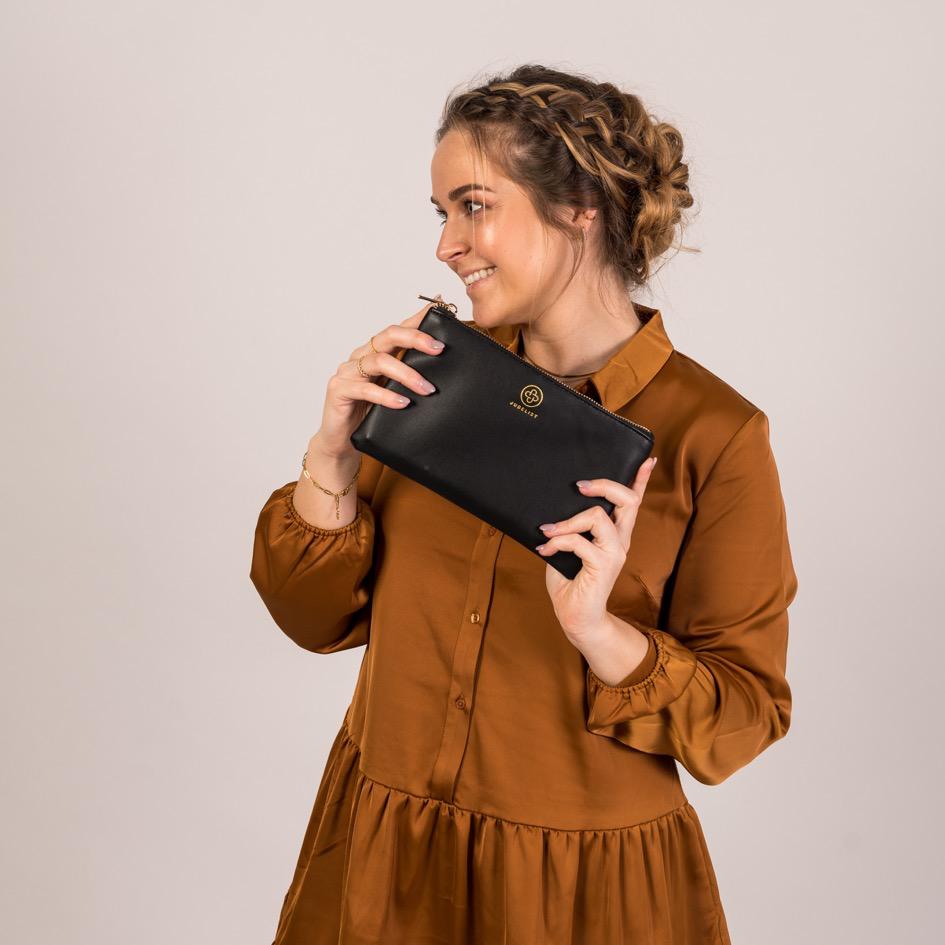 Die Mum Pouch in schwarz wird mit beiden Händen festgehalten und gezeigt