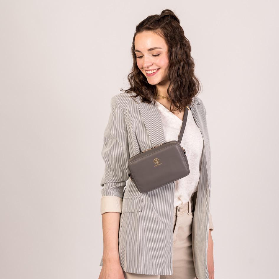 Eine junge Frau trägt die Jade in graphite  crossbody über dem Oberkörper