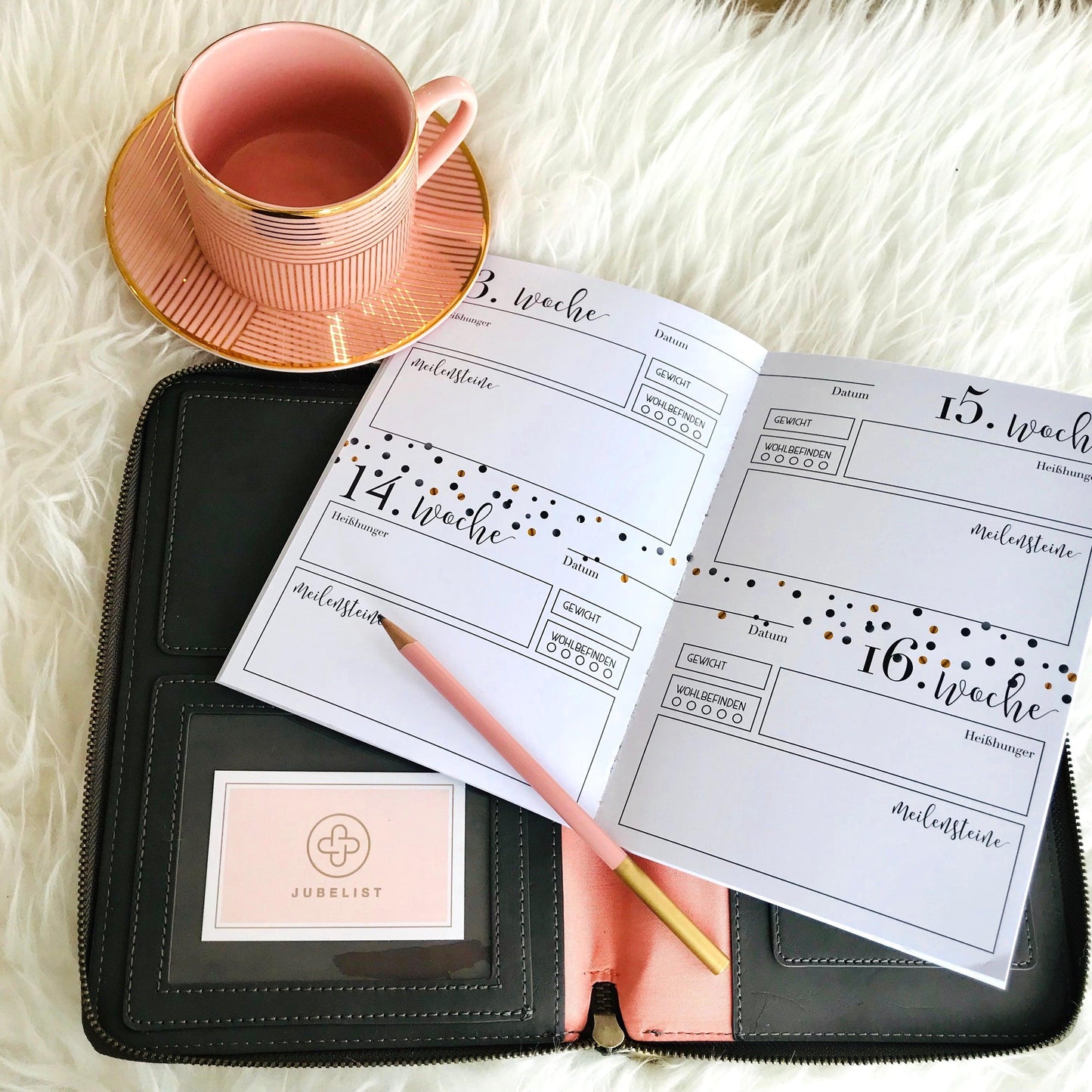 Das Tagebuch liegt aufgeschlagen auf einer Wallet in Graphite und ein Stift liegt oben auf