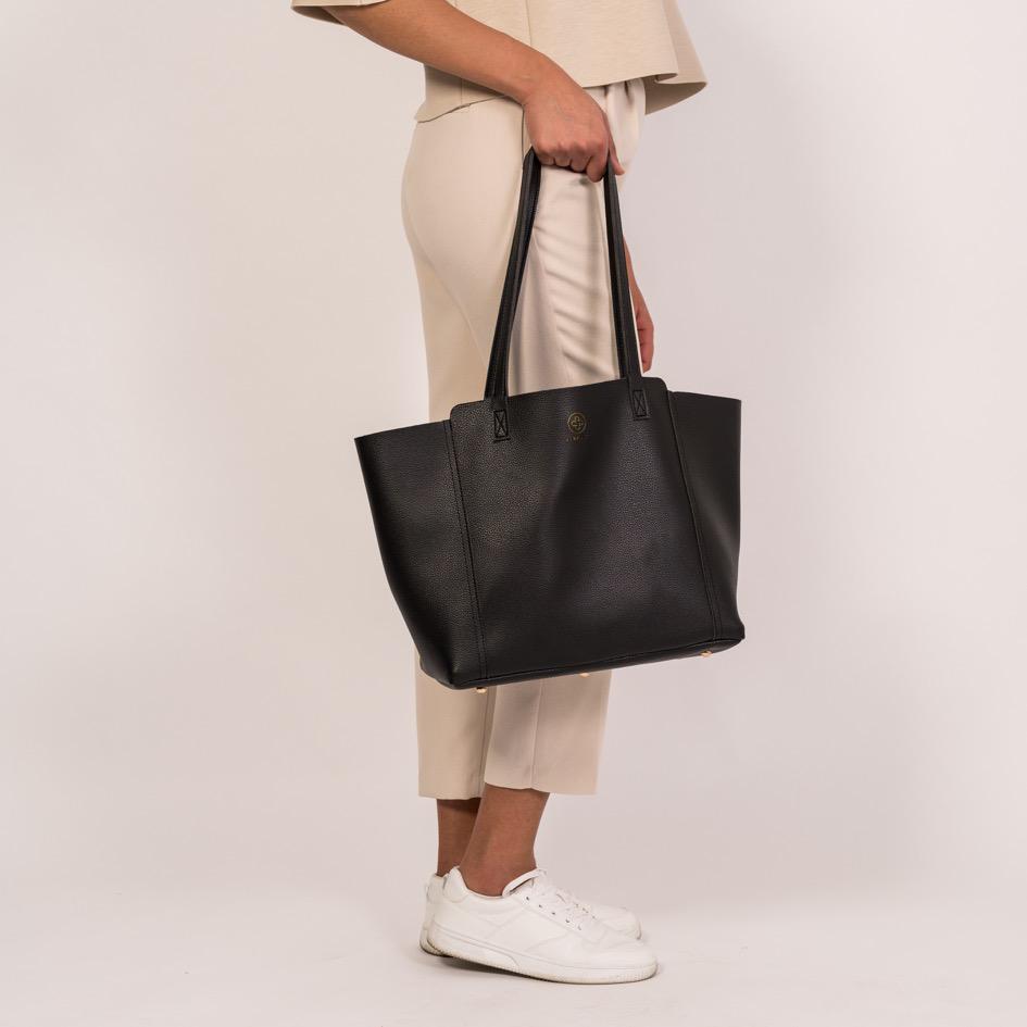 Der Shopper in schwarz wird an den Henkeln getragen