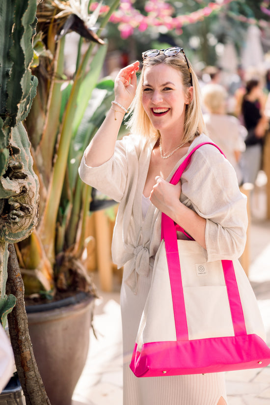 Tina Ruthe steht mit der pink farbenden Canvas Bag vor einem trübseligen Markt im Hintergrund.