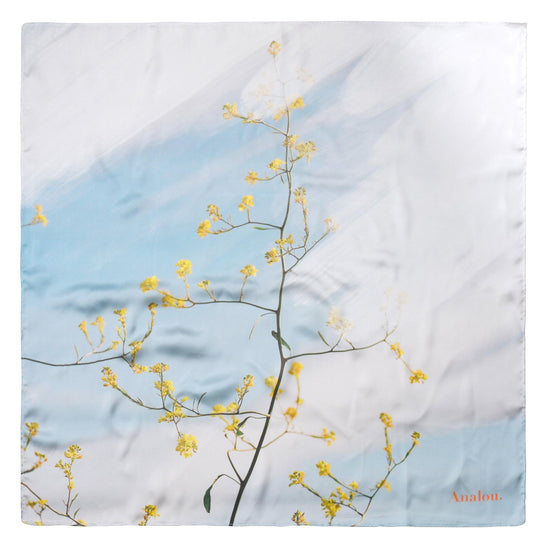 Laden Sie das Bild in den Galerie-Viewer, Das Tuch hat einen hellblauen und weiß gemusterten Hintergrund und es ist ein Zweig mit gelben Blüten zu sehen.
