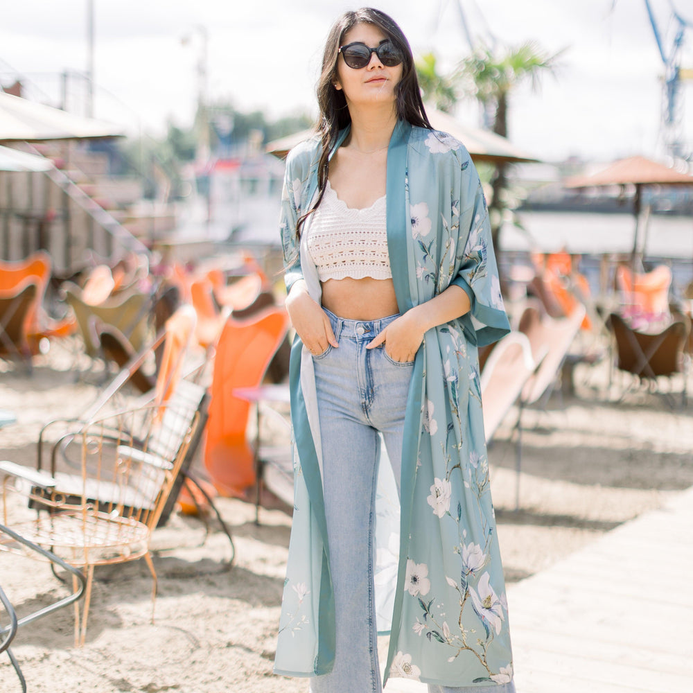 
                  
                    Ein Model trägt zu ihrer hellblauen Jeans und einem cremefarbenen Stricktop  den Kimono
                  
                