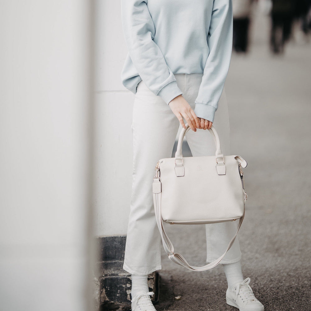 
                  
                    Ein Model trägt zu einer weißen Hose und einem hellblauen Pullover eine Grace in white 
                  
                