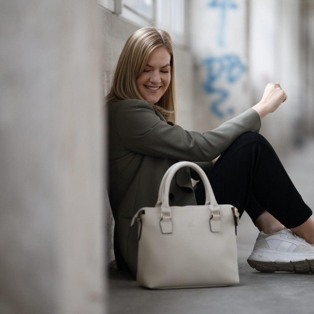 
                  
                    Tina Ruthe sitz auf dem Boden und neben ihr steht eine Grace in white
                  
                