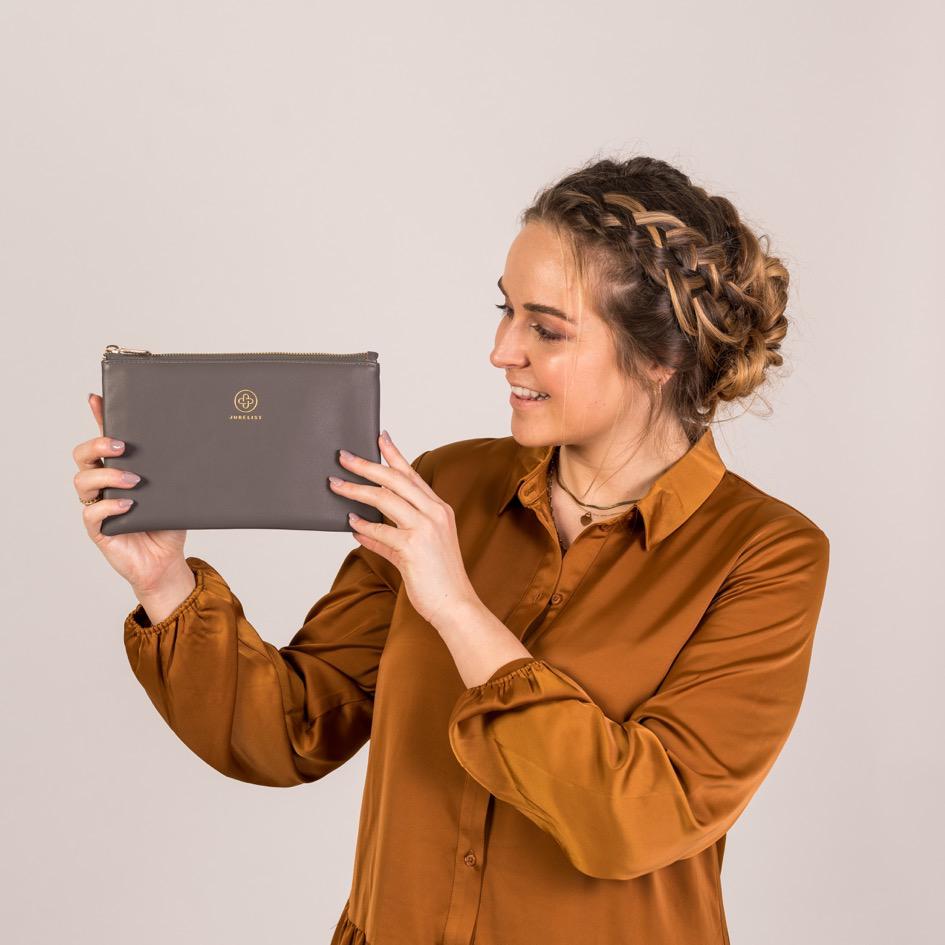
                  
                    Die Pouch in graphite wird seitlich in die Höhe gehalten und gezeigt
                  
                