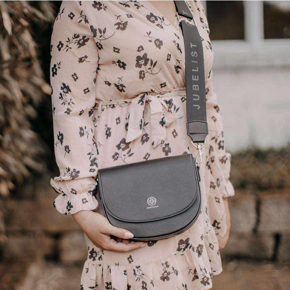 
                  
                    Die Saddle Bag in schwarz silber mit dem passenden Fashion Strap in schwarz silber wird in die Kamera gehalten
                  
                