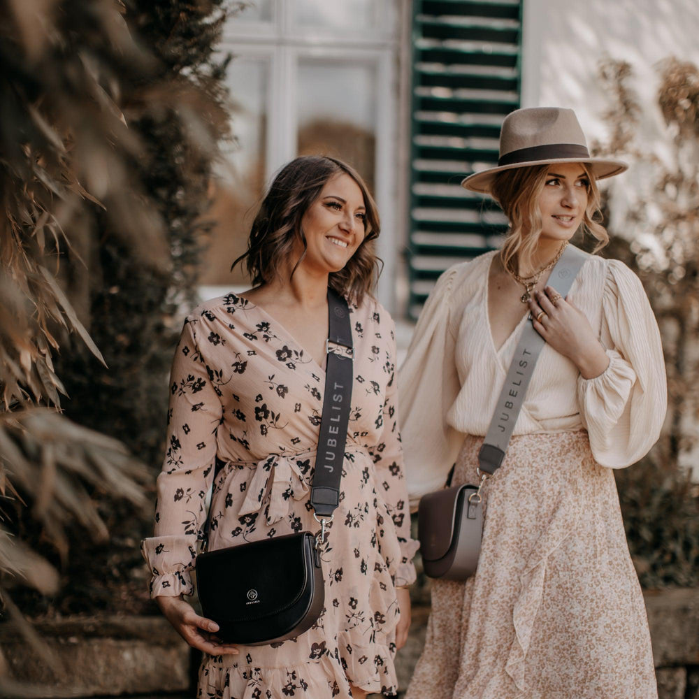 
                  
                    Zwei junge Frauen stehen nebeneinander in sommerlichen Kleidern und jede trägt eine Saddle Bag mit einem Fashion Strap
                  
                