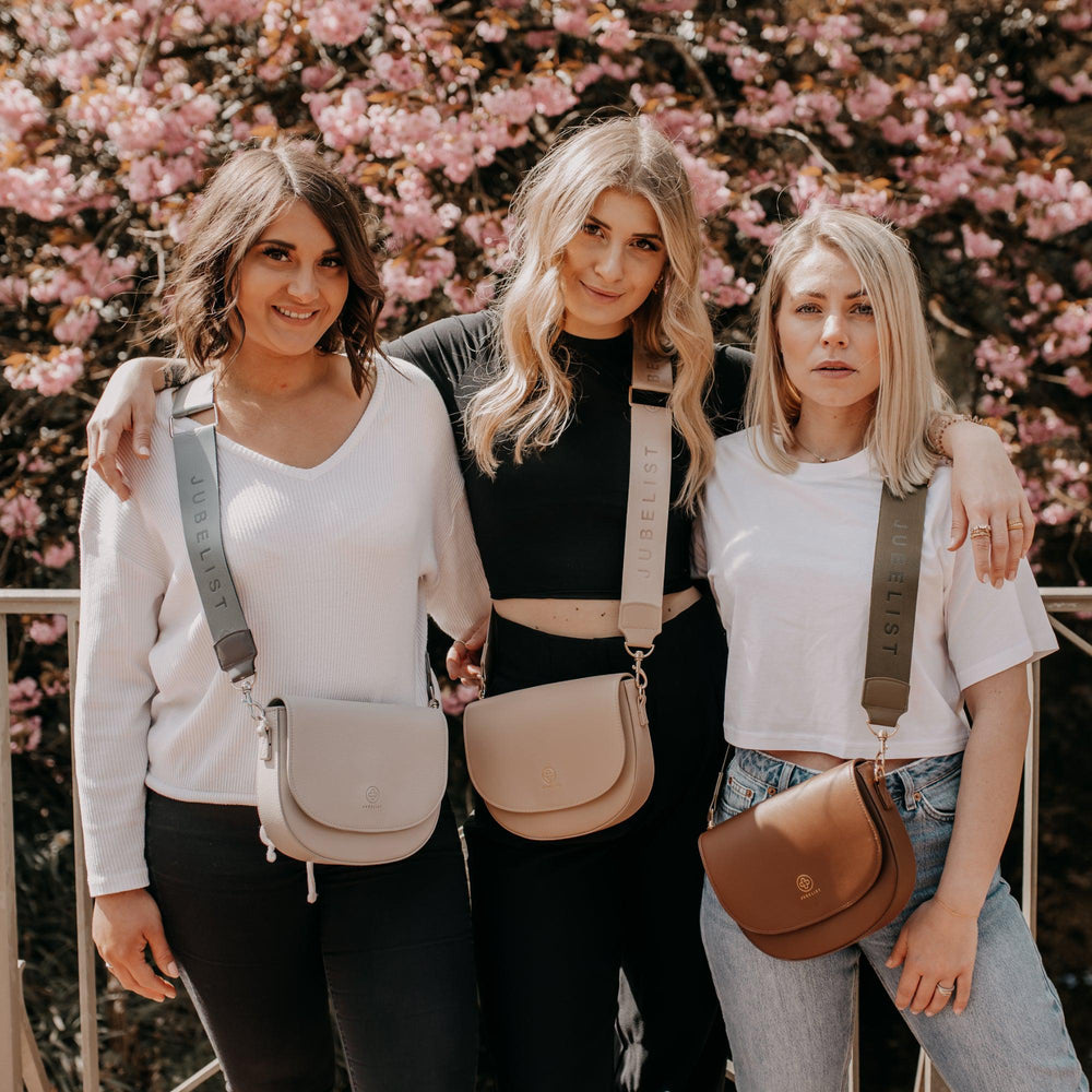 
                  
                    Dre junge Frauen stehen nebeneinander und jede trägt eine Tasche mit einem Fashion Strap dabei sind die Farben unterschiedlich
                  
                