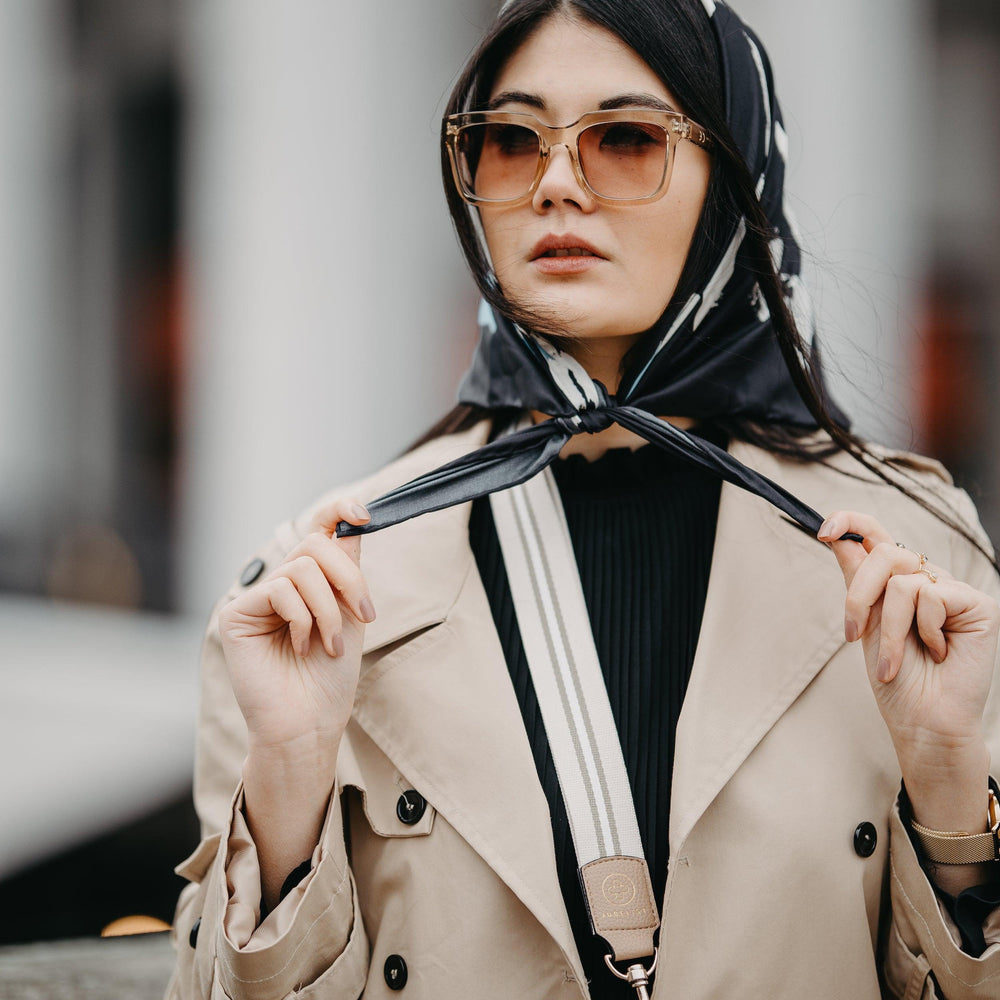 
                  
                    Der Universal Strap in sand wird zu einem schwarz und beigen Outfit getragen
                  
                