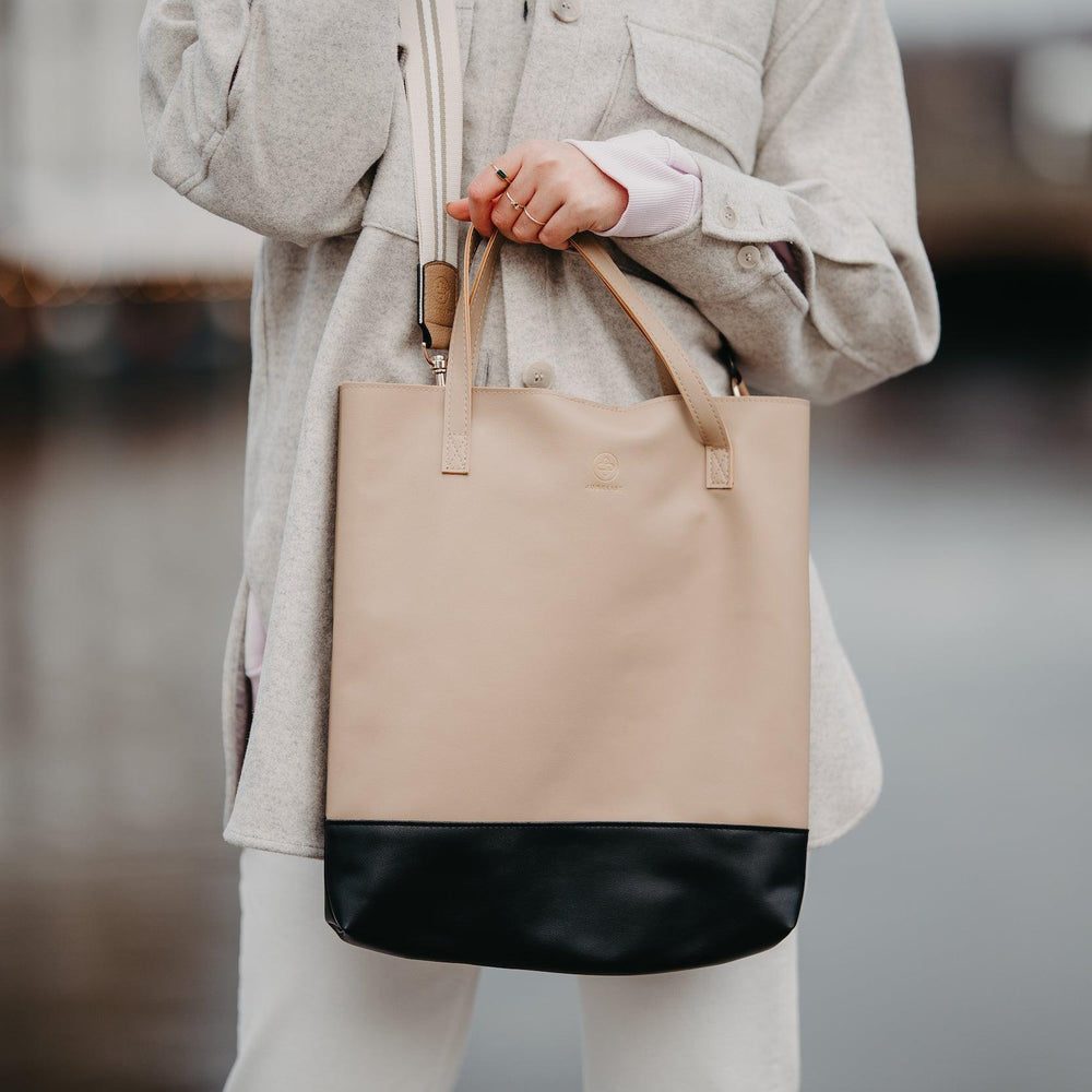 
                  
                    Die Leni in sand hat den Universal Strap in beige weiß als Tragegurt
                  
                