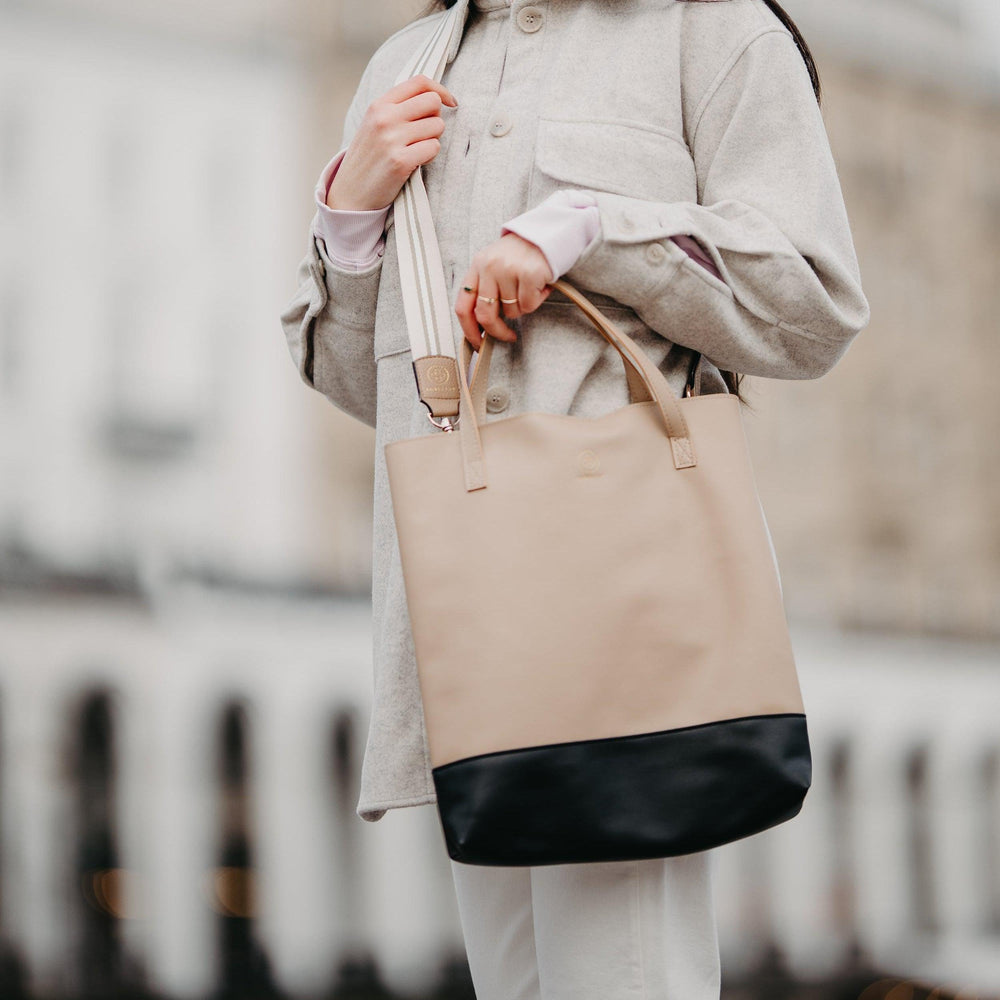 
                  
                    Die Leni in sand wird mit dem Universal Strap in beige weiß crossbody getragen
                  
                