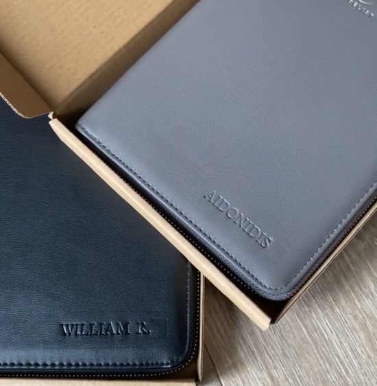 Eine Wallet in graphite silber und eine Wallet in schwarz liegen leicht übereinander und die Personalsierungen sind zu sehen