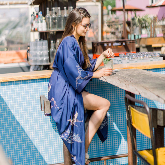 Laden Sie das Bild in den Galerie-Viewer, Ein Model sitzt in einem  Kimono an einer Strandbar 
